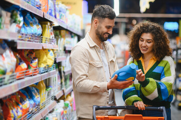 Fototapeta na wymiar Couple shopping for laundry detergent in supermarket aisle
