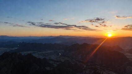Sunrise casting light across rugged mountain landscape and ridges.