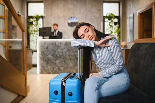 Tired woman sleeping in hotel lobby experiencing jet lag