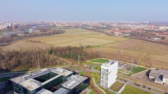 Aerial Cityscape: An expansive view of a bustling city, with modern buildings and infrastructure coexisting alongside natural green spaces and open fields.