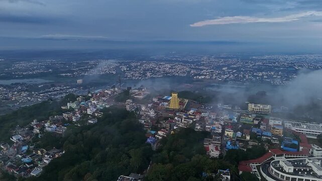 Cinematic drone view of Sri Chamundeshwari Temple atop Chamundi Hills amid misty cityscape in mysore
