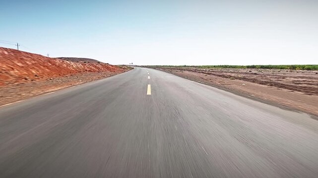 Car POV driving along an empty asphalt road through a desert landscape at high speed, Xinjiang, China