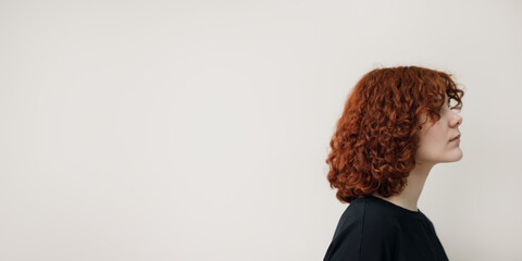 Profile portrait of a woman looking away with significant negative space for text, ideal for creative banners and storytelling advertising. © Aigul Sabirova