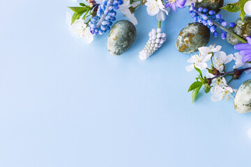 Easter flat lay. Stylish easter eggs and cherry flowers on blue background. Easter celebration, season greetings mockup. Spring modern floral banner © sonyachny