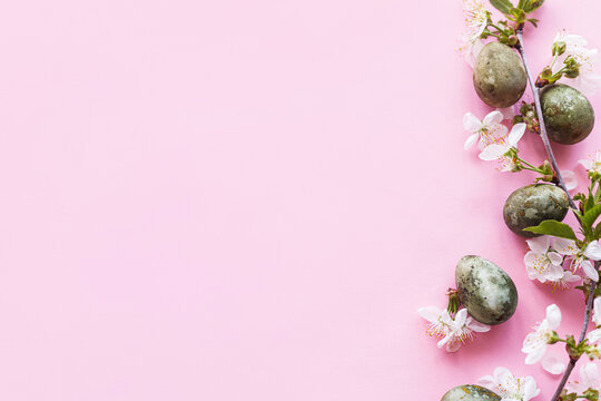 Easter flat lay. Stylish easter eggs and cherry flowers on pink background. Easter celebration, season greetings mockup. Spring modern floral banner