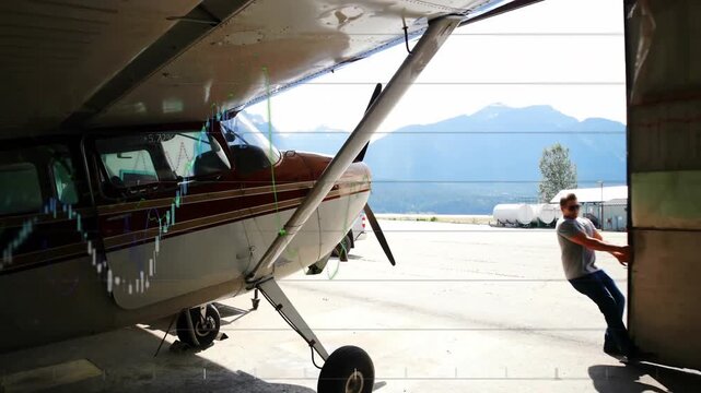 Airplane in hangar with financial graphs and data processing animation overlay