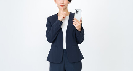 スマホを持つスーツを着た女性 © ponta1414