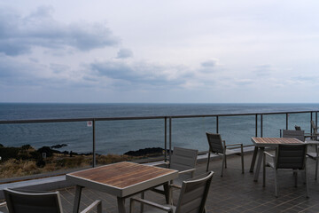 Fototapeta premium outdoor cafe and overcast seascape at Seopjikoji in Jeju Island, South Korea
