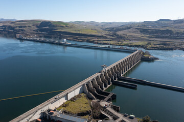Obraz premium Aerial drone footage of The Dalles Dam hydroelectric facility on the Columbia River in The Dalles, Oregon, USA generating renewable energy and supplying electricity to the regional power grid