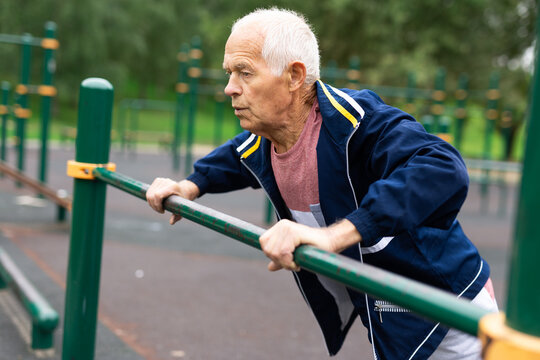 Senior european man doing push-ups outdoors