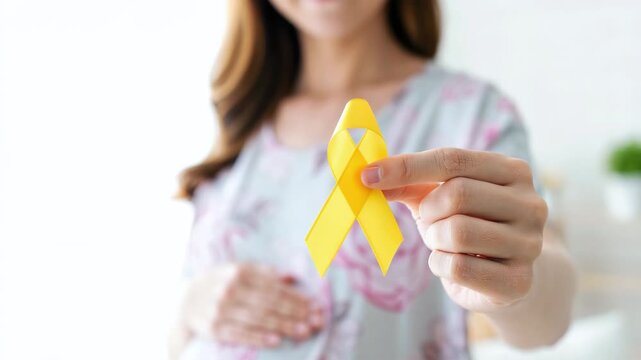 Yellow ribbon for endometriosis awareness month, closeup hand holding support emblem, pregnancy journey with pelvic pain, menstrual health, infertility, ivf, iui paths, treatment, advocacy