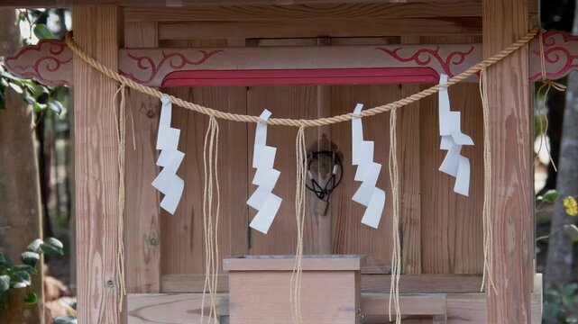 神社の小さな祠と風に揺れる紙垂