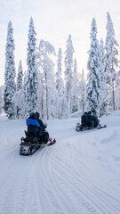 Exploring the snowy landscapes of Akaslompolo, Lapland during a thrilling snowmobile adventure