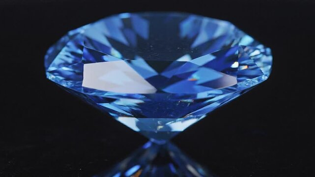 Close up of a brilliant round cut blue diamond or sapphire with light flares