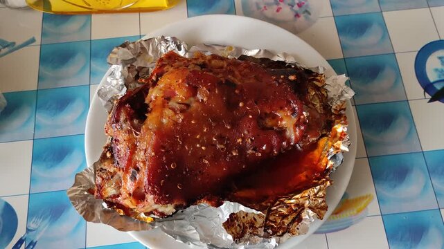 Roasted pork knuckle on plate with spices and sauce
