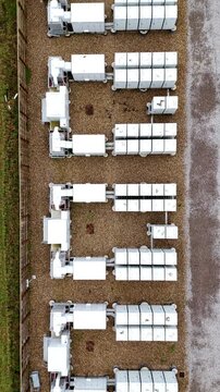 Top-down aerial drone view of a large-scale Battery Energy Storage System (BESS) in Burwell, UK, featuring modular lithium-ion battery containers.