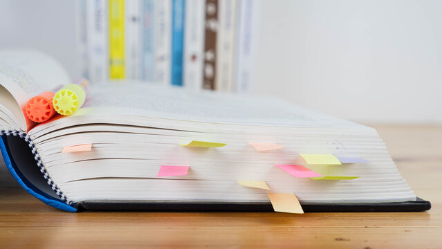 Book instruction manual reference sticky paper note blur background.