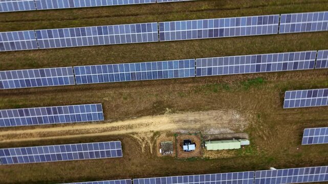 Aerial drone view of a solar panel array on the former RAF Alconbury site, renewable energy infrastructure under cloudy UK skies in Cambridgeshire.