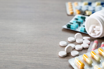 Concept of daily medication routine and chronic disease management. White tablets spilling from...