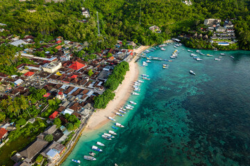Turquoise water, coral reef, and anchored boats line the coast of Nusa Penida, Indonesia. © whitcomberd
