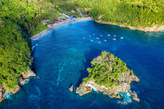 High angle aerial view of a beautiful tropical bay with sandy beach, boats, and blue sea