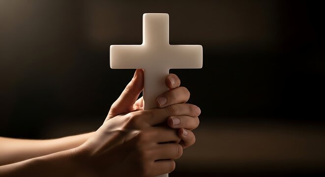 Hands holding a white Christian cross.