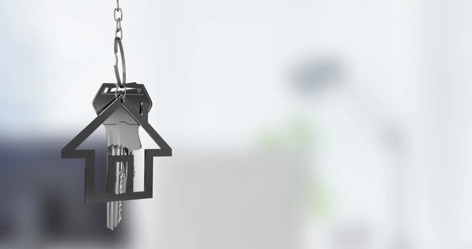 Animation of silver house key fob and key dangling over out of focus interiors with copy space