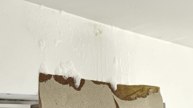 Foam from bleach cleaner running down wall after mold treatment. Household cleaning process and disinfecting damp wall surface in home interior