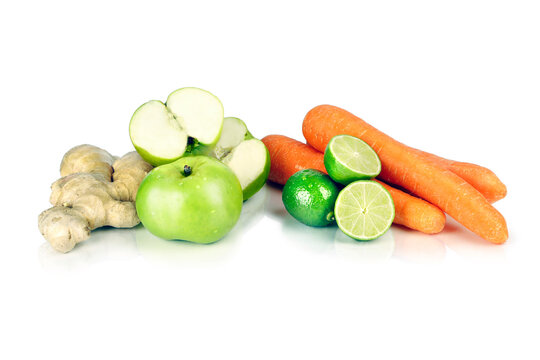 Assortment of Fresh Fruits and Vegetables Including Apples, Carrots, Ginger and Limes on White Background