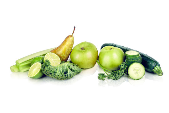 Assortment of Green Fruits and Vegetables Including Kale, Apples, Pears, Limes and Cucumber on White Background