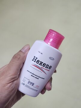SONGKHLA, THAILAND - MAR 10, 2024 : hand holding a bottle of Hexene cosmetic product for skincare and personal care use