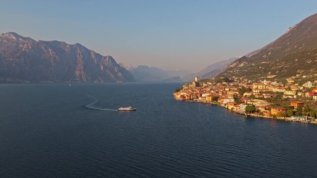 Veduta aerea da drone del paese di Malcesine sulle sponde del Lago di Garda in provincia di Verona in Italia nel mese di marzo con un traghetto in navigazione