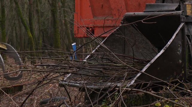 Leaf Shredder on Axle in Action. Mobile wood and branch shredder in the city park. Agricultural machinery, wood chipping machine. Machinery wood shredder the chipper at work for tree branches
