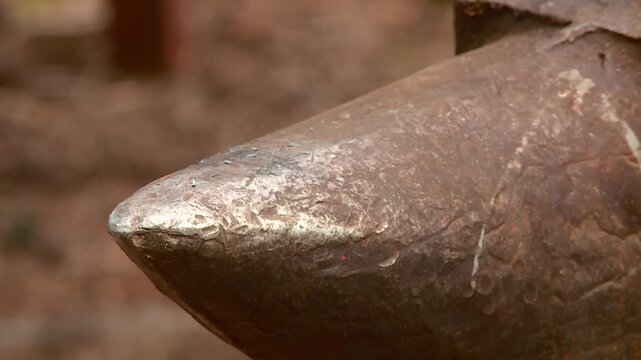 a blacksmith forges a metal product on an anvil