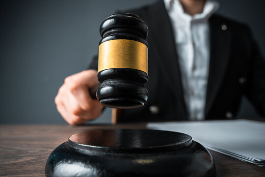 Judge holding a gavel, symbolizing authority, legal decision-making, and the administration of justice, representing fairness and the power of the courtroom.