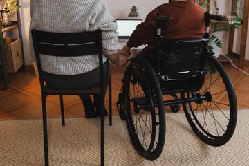 Fototapeta premium A woman with her boyfriend with disability holding hands