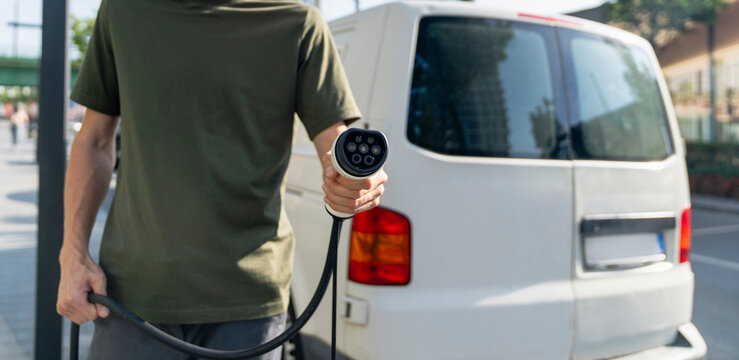 Driver with charging plug next to of electric van
