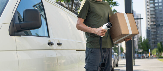 Driver with charging plug next to of electric van