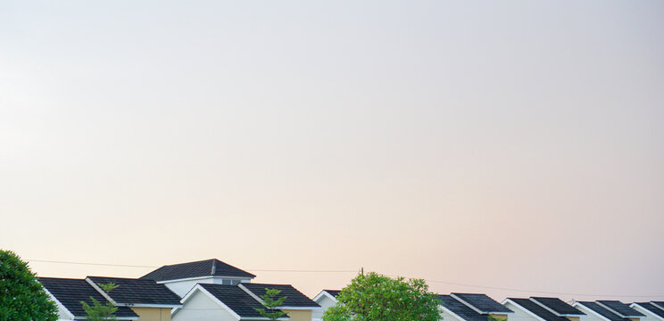 Modern house roofs and sky background at sunset