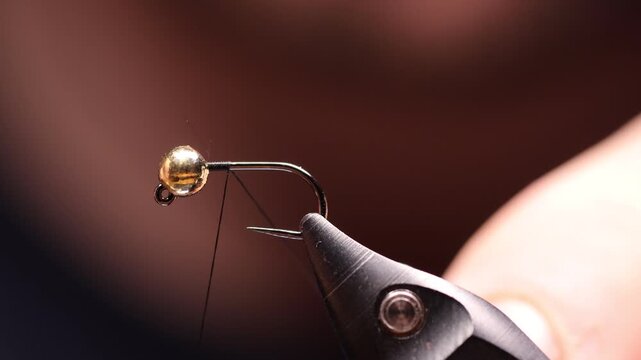 Goldkopfnymphe im Bindestock &ndash; Makroaufnahme einer handgebundenen Fliege zum Fliegenfischen