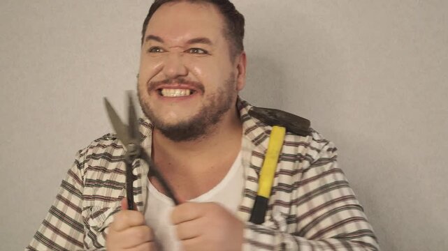 A handyman man poses with various tools