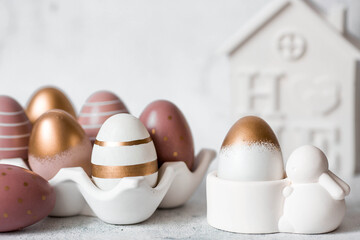 Easter eggs with geometric patterns in beige and golden tones and an Easter bunny. The concept of the bright Easter holiday in 2026.