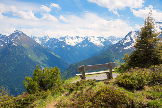 bench on Penken mountain with a view of the snow-covered Zillertal main ridge
