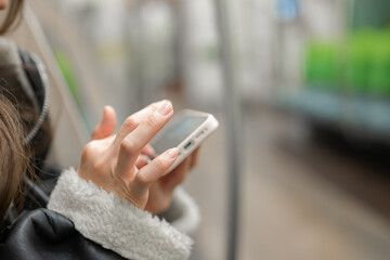 電車でスマホを見る女性