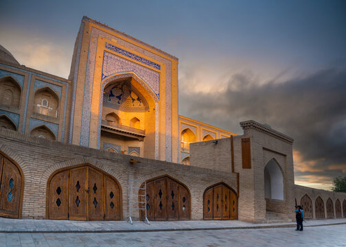 Khiva, Khorezm Province, Uzbekistan - May 31, 2025: Tourist Photographing the Muhammad Rahim Khan Madrasah (Muhammad Rahimxon Madrasasi) at Sunset
