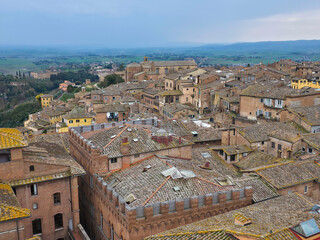 Obraz premium High angle panoramic view of Siena historic center with traditional terracotta rooftops and the Tuscan countryside, Italy