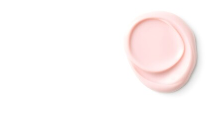 A close-up view of a pink cosmetic cream smear on a clean white surface from directly above