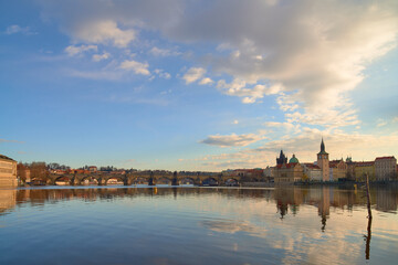Obraz premium Charles Bridge and Vltava River reflecting historic Prague skyline at sunset