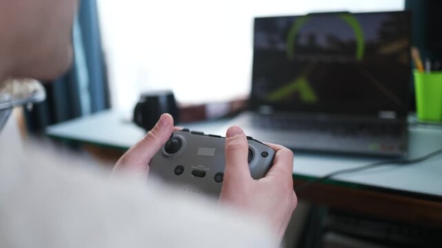 flight simulator concept. Male hands hold the joystick from the fpv drone on the background of a blurry monitor.