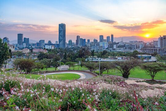 Sunset view of Addis Ababa with  a serene blend of lush greenery, flowering gardens, and a striking modern skyline.